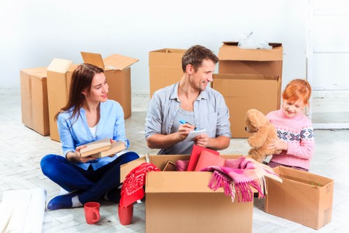 Removal team handling boxes and furniture in a North London flat
